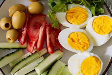 Fresh Healthy Meal with Eggs Cucumber Tomato Olives and Herbs