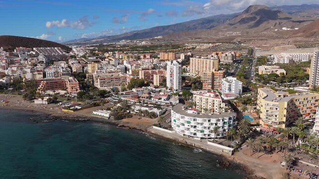 Aerial view of Los Cristianos, southeast coast in Tenerife island. Drone POV from mountain Guaza located in Canary Island of Spain.