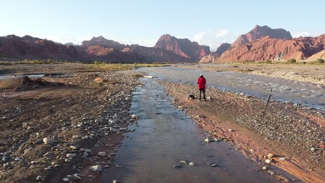 man flying a drone over the tianshan mysterious grand canyon in xinjiang, china