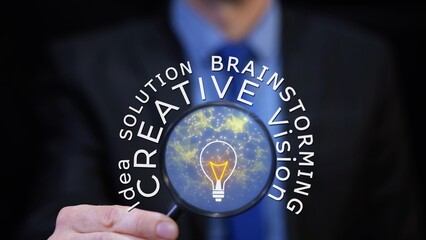 Businessman with magnifier and glowing light bulb presents: idea, vision, solution, creativity. Graphic