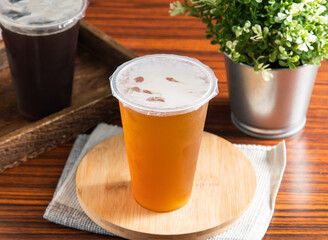 Refreshing iced green tea. Perfect for cafe promotions, showcasing a modern beverage on a wooden table with a decorative plant