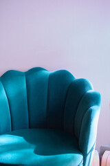 Blue velvet art deco accent chair against pastel background
