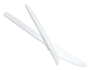 Two white, disposable plastic knives are overlapping against a stark, black background