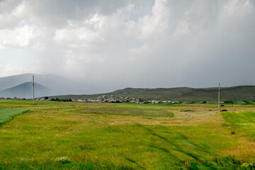 Javakheti, Georgia. 18 July 2020. Steppe landscape with mountains and village in the distance