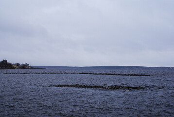City embankment on the shore of a lake with an overcast sky. Tourist walks, recreation. City.