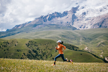 Female runner running on the high altitude grassland mountain top