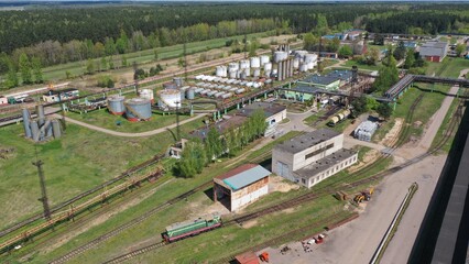 A railway line leading to a large oil refinery. Oil tanks on the railway tracks.