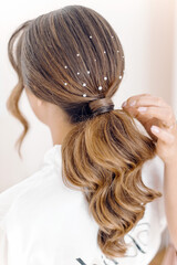 Naklejka premium Bride hairstyle from behind, elegant wedding hair updo for ceremony, close-up of bridal hair preparation and styling, back view of hairstyle for special day