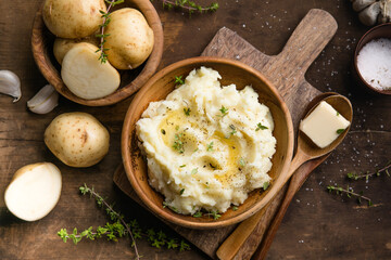 Mushed potatoes top view with raw potatoes and spices