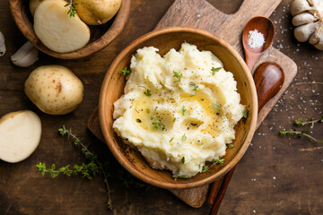Mushed potatoes top view with raw potatoes and spices