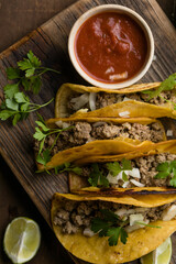 Birria tacos with dipping sauce on wooden board