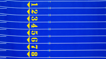 Aerial image of a new blue and yellow eight, 8, lane running track with white lane lines and other markings.	