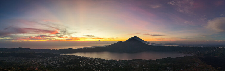 serene volcanic sunset, tranquil twilight at volcanic lake with fading village lights and moody...