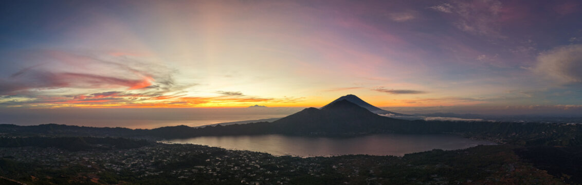 serene volcanic sunset, tranquil twilight at volcanic lake with fading village lights and moody Kintamani Batur Abang Angung Bali