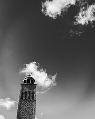 Minimalist church tower with clouds in black and white