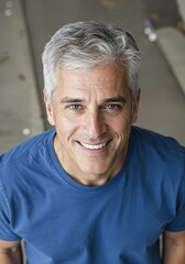 Fototapeta premium Confident Smile: An attractive man, with distinguished silver hair and a radiant grin, exudes confidence. His expressive eyes and approachable demeanor capture a sense of optimism. 