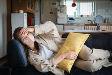 具合が悪くてリビングで寝ている女性
A woman who is unwell and sleeping in the living room