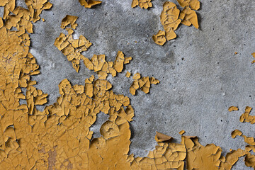 Peeling paint on the wall. Old concrete wall with cracked flaking paint. Weathered rough painted surface with patterns of cracks and peeling. High resolution texture for background and design. Closeup
