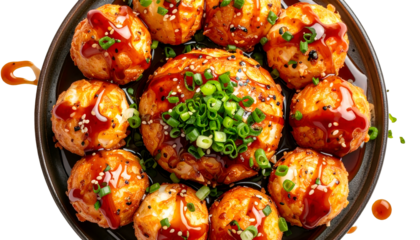 A plate of golden-brown, saucy, spherical food topped with green onion and sesame seeds