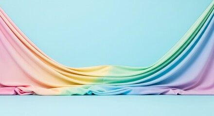 Soft pastel rainbow fabric draped across a pastel blue background