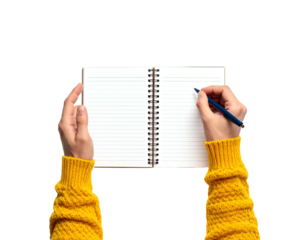 Overhead shot of hands holding open notebook, writing with a blue pen