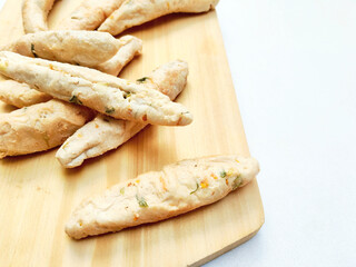 Stack of Traditional Indonesian Otak Otak Fish Cakes on Wooden Board