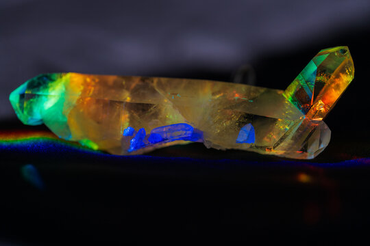 Quartz crystal in prism light with small blue clusters