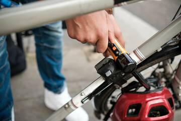 Cyclist securing bike with u-lock on city street