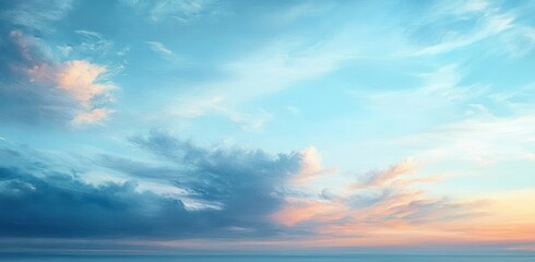 Obraz premium Expansive sky at sunset with soft clouds displaying shades of blue, pink, and orange creating a serene and peaceful atmosphere