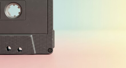 Fototapeta premium Close-up of a vintage cassette tape with subtle scratches against a soft pastel gradient background