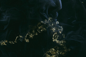 Abstract colorful smoke, dark background. Moving flow of golden black paints, fluid art, space sky