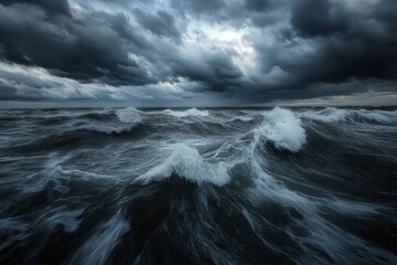 Fototapeta premium Dark stormy ocean with large turbulent waves under a heavy cloudy sky portraying intense and dramatic natural power