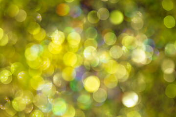 Fototapeta premium Bright yellow bokeh on dark background – festive glitter lights and blurred New Year background