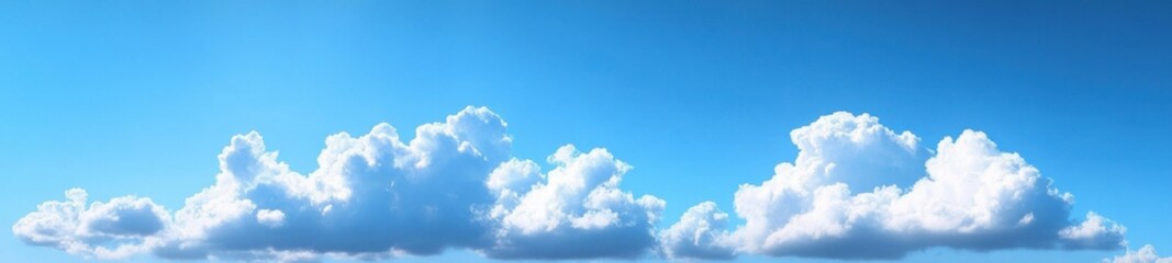 Bright blue sky with large, fluffy white clouds floating peacefully during a clear day