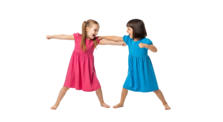 Two young girls playfully mock fighting each other, showcasing sibling rivalry and childhood antics with determination