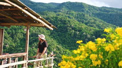 A woman sitting in wooden cabin and looking at a mountain views