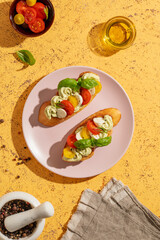 Caprese toasts or bruschetta with mini mozzarella cheese, cherry tomato and basil. Top view
