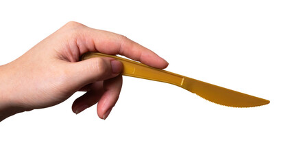 Female hand holding a gold plastic cooking knife isolated on white background.