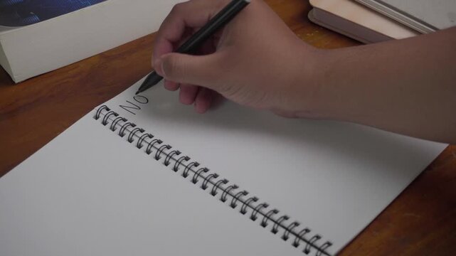 Person wrote "Notes Today" on his notebook. On a wooden table.