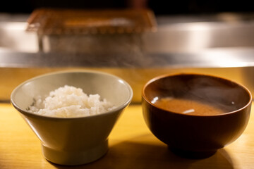 A bowl of rice and soup served on the table