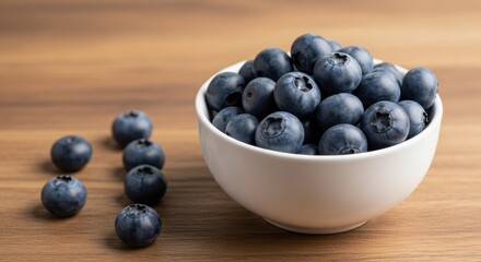Fresh and flavorful blueberries in a white bowl on wooden surface closeup