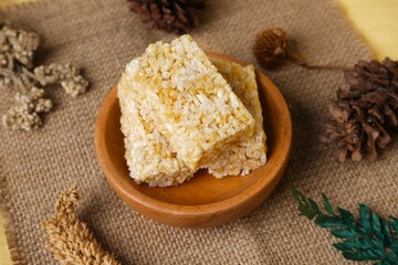 Crispy Jipang (Bipang) sweet rice crackers served in a wooden bowl on burlap with rustic natural decor, perfect for snack themes.
