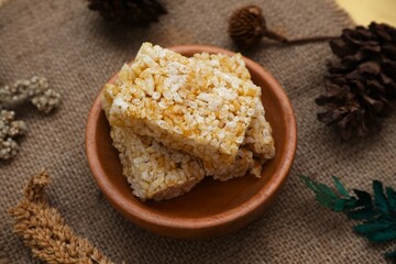 Crispy Jipang (Bipang) sweet rice crackers served in a wooden bowl on burlap with rustic natural decor, perfect for snack themes.