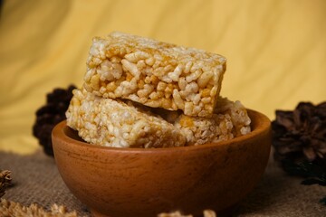 Crispy Jipang (Bipang) sweet rice crackers served in a wooden bowl on burlap with rustic natural decor, perfect for snack themes.	