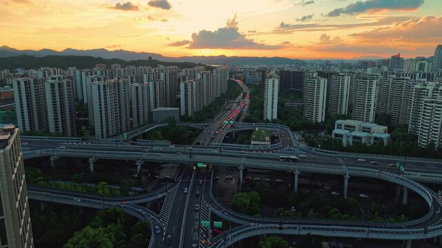 Aerial view of a residential buildings alongside a multilane highway interchange filled with moving vehicles