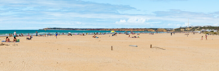 Obraz premium Conil, Spain - April 17, 2025: Views of Conil beach in Cadiz, with tourists sunbathing during the Easter holidays in Conil, Spain.