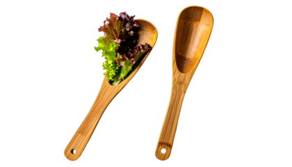Wooden spoons, one with lettuce, presented against black backdrop
