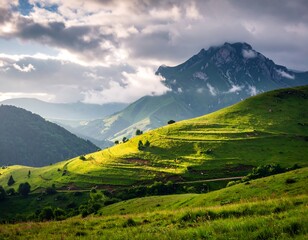 Green hills and a mountain peak, bathed in sunlight and clouds