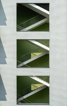 Multi-Level Green Stairwell Through White Brick Wall Openings