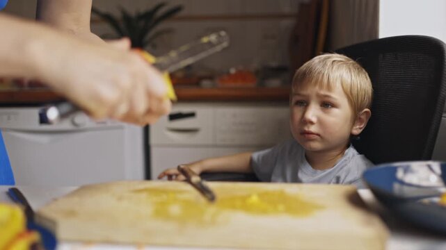 Mother peeling fresh mango for son